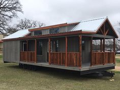 a tiny house on wheels in the middle of a field