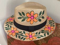 This hand-painted fedora is a beautiful floral straw hat, perfect as a summer beach hat and sun protection hat. This stylish vacation hat and beach accessory is ideal for boho festival fashion, making it a unique and custom gift for her. It provides excellent sun protection while adding a touch of bohemian flair to any summer outfit, making it a perfect beach or vacation accessory. Hand-Painted Floral Fedora: A Unique Summer Accessory Hand-painted floral design on a tan straw fedora, featuring o Hand Painted Straw Hats, Painted Straw Hats, Wearable Crafts, Hat Painting, Panama Style, Hat Diy, Summer Straw Hat, Beach Hats, Painted Hats