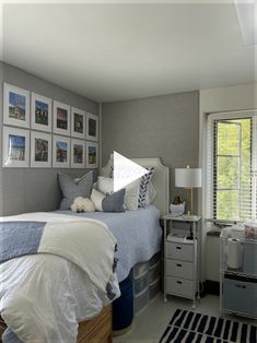 a bed room with a neatly made bed and pictures on the wall