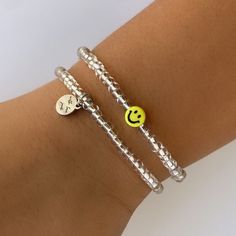 Minimalist Smiley Face Bracelet  Select your QUANTITY  * 1 Bracelet  * Set of 2 Bracelets * Set of 3 Bracelets * Set of 4 Bracelets  * Set of 5 Bracelets  Get one for yourself or Get a set and gift them to your friends, daughters, cousins etc.  Each Bracelets features a stainless steel charm logo.  Made using; metallic lined clear beads, acrylic yellow smiley face bead, stainless steel charm, durable elastic cord.  All orders are Custom and made to order. ✨Sizing Suggestions ✨ * Child 2-4yrs 5.0 Cheap Adjustable Smiley Face Friendship Bracelets, Cheap Cute Smiley Face Beaded Bracelets, Cheap Everyday Friendship Bracelets With Smiley Face, Trendy Silver Hypoallergenic Friendship Bracelets, Trendy Silver Friendship Bracelets With Round Beads, Trendy Birthday Charm Bracelet, Trendy Hypoallergenic Silver Friendship Bracelets, Trendy Silver Bracelets With Letter Beads, Trendy Silver Bracelet With Letter Beads