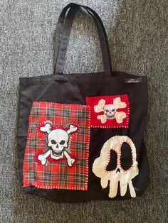 a black bag with skull and crossbones is on the floor next to a pair of scissors