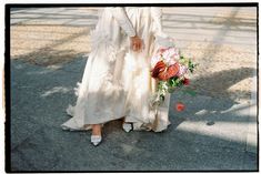 a woman in a white dress holding a bouquet of flowers