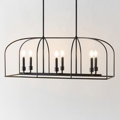 a chandelier with five lit candles hanging from it's center, in an industrial style