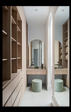 a large walk in closet with two stools