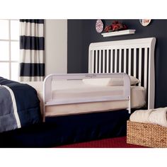 a white crib bed with blue and white striped curtains