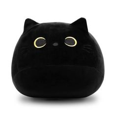 a black cat pillow with yellow eyes on it's head and ears, sitting in front of a white background