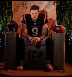 a man sitting in a chair with a football and helmet on it's feet