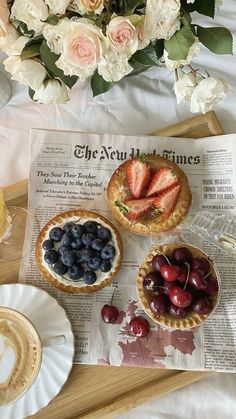 three pies and fruit on a table with flowers