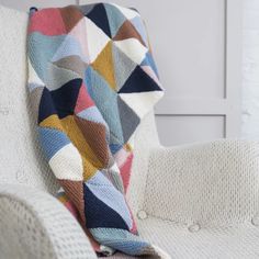 a multicolored blanket sitting on top of a white chair