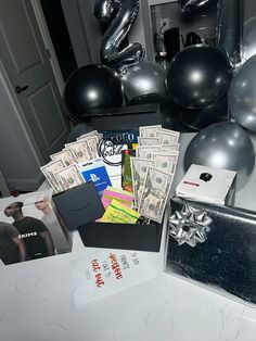 a table topped with black balloons and money