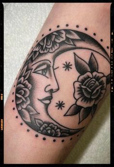 a black and white tattoo on the arm of a woman's head with a crescent moon