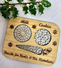 a personalized cutting board with snowflakes on it and the words cookies for santa and his reindeer