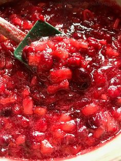 cranberry sauce in a pot with a wooden spoon