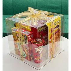 a clear box filled with lots of different types of snacks on top of a table