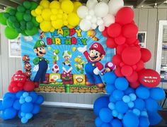 balloons and streamers decorate the entrance to a mario birthday party