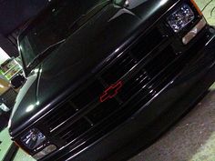 the front end of a black truck parked in a garage