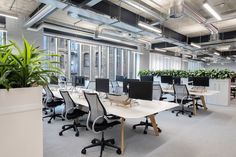 an office with plants and desks in it