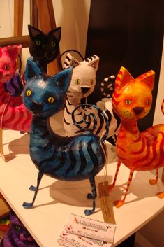 many different colored cats are on display together