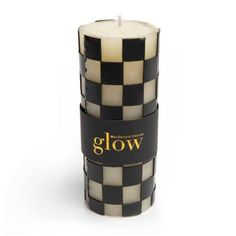 a black and white candle with the words glow written on it in gold lettering next to an image of a checkerboard pattern