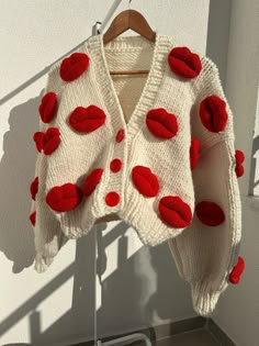 a red and white sweater hanging on a clothes rack