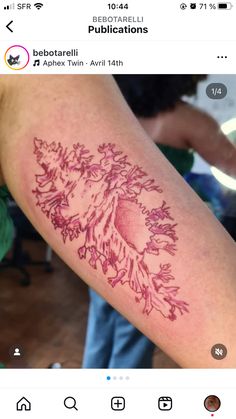 a person with a tattoo on their arm that has pink ink in the shape of a tree