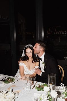 a bride and groom sitting at a table in front of a window with the words the terrace on it