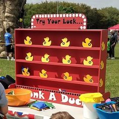 a little boy sitting in front of a display with rubber ducks on it