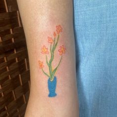 a blue vase with flowers on the arm