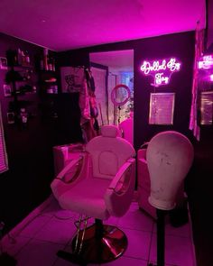 a pink chair sitting next to a hair dryer on top of a table in a room