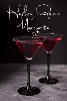 two glasses filled with red liquid on top of a table