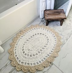 a crocheted doily sits on the floor next to a bathtub