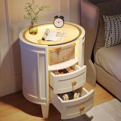 a white table with drawers and a clock on the top, next to a couch