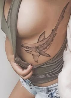 a woman with a shark tattoo on her stomach