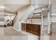 an empty room with a sink, mirror and stairs in the backround area