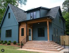 a blue house with steps leading up to the front door and second story porch area