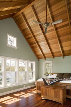 a bedroom with wood floors and vaulted ceiling