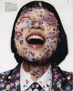 a woman with her face covered in confetti and sprinkles on her face