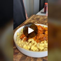 a white bowl filled with macaroni and cheese on top of a wooden table