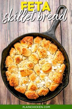 a skillet filled with bread on top of a wooden table