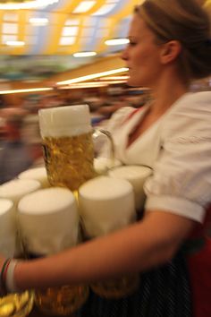 a waitress carrying beer mugs and serving them