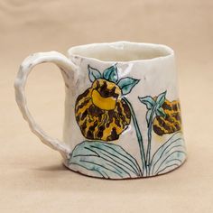 a ceramic mug with flowers painted on it