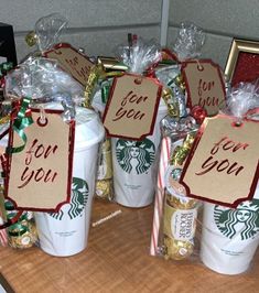 starbucks coffee cups decorated with holiday decorations and candy canes for you to give as gifts