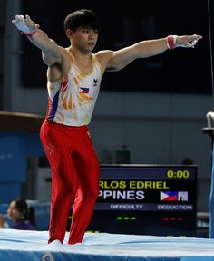 a man standing on top of a blue and white trampoline with his arms outstretched