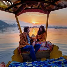 two people are sitting in a boat on the water at sunset, with one person wearing headphones