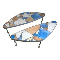 two metal surfboards sitting on top of each other in front of a white background