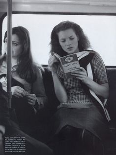 two women sitting on a bus reading books