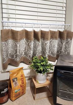 a potted plant sitting next to a toaster oven on a kitchen counter near a window