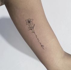 a woman's arm with a single flower tattoo on the left side of her arm