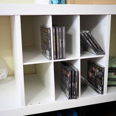 a white book shelf filled with dvd's