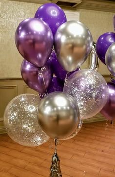 purple and silver balloons are floating in the air